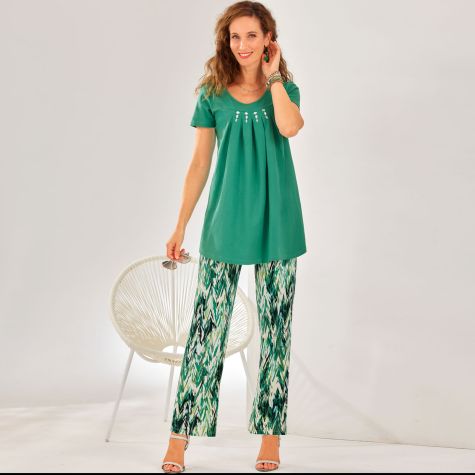 Mettez-vous au vert… et avec classe ! C’est la promesse de ce tandem élégant et tout confort qui réunit tunique manches courtes et pantalon imprimé en maille.