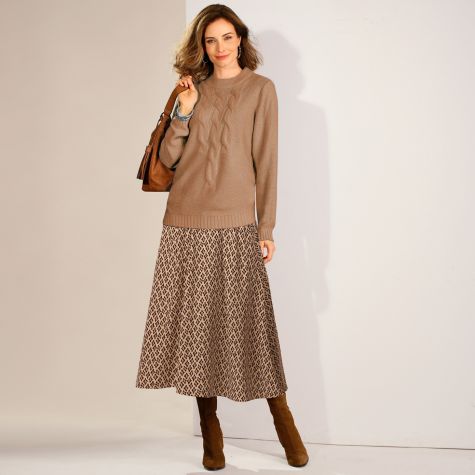 Comment rendre un look tendance avec 2 pièces classiques ? En associant un pull à torsades à col montant, avec une jupe longue imprimée aux couleurs neutres assorties et aux matières qui contrastent !