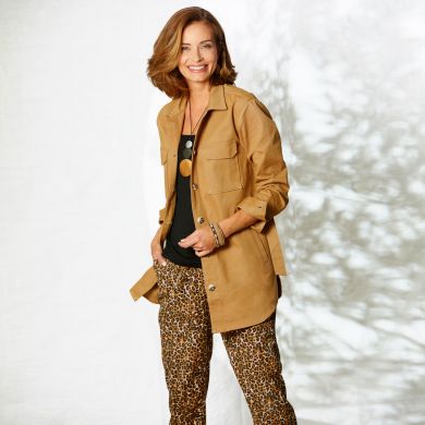 Veste saharienne en twill coton sur son pantalon safari, et sautoir en bois dorés.