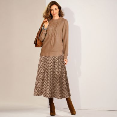Comment rendre un look tendance avec 2 pièces classiques ? En associant un pull à torsades à col montant, avec une jupe longue imprimée aux couleurs neutres assorties et aux matières qui contrastent !