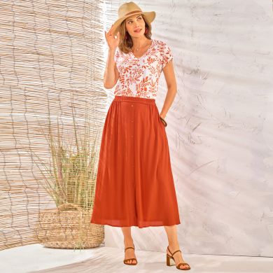 Une tenue féminine et élégante, pour accueillir en toute légèreté les jours ensoleillés, vêtue d’une tunique imprimée et d’une jupe à boutons fantaisie couleur tomette !