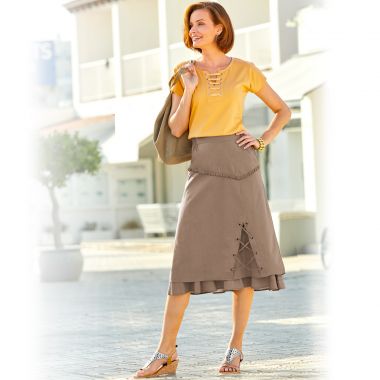 Tee-shirt au décolleté lacé, sa jupe longue 2 en 1 et ses sandales style spartiate en cuir argenté ajouré, à talon compensé façon liège